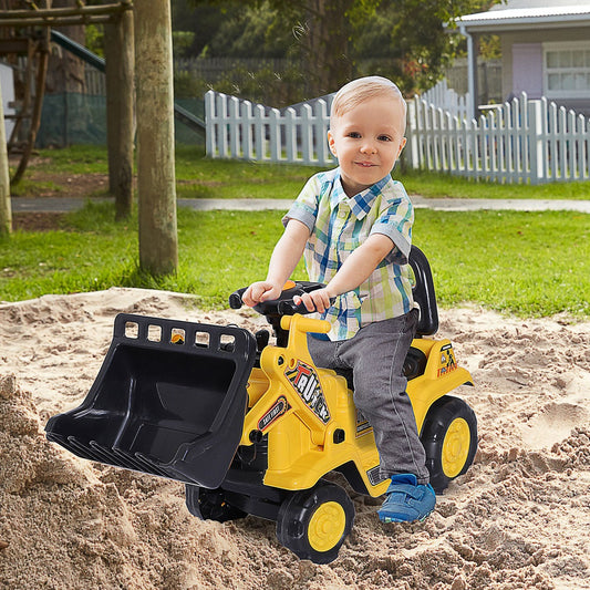 Child riding the ride-on bulldozer in sand